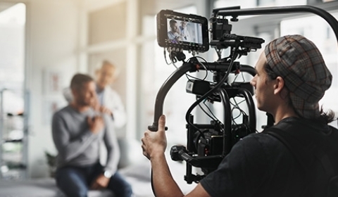 Camera man filming a scene in a doctor's office