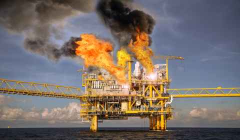 Oil rig on fire in the middle of the ocean