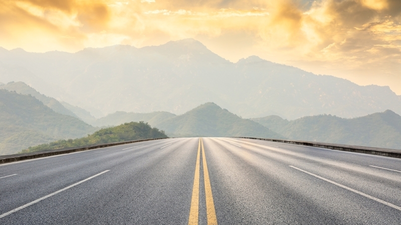 Eye level view of a highway with mountains in background