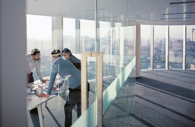 Business people in an office working overlooking the city.